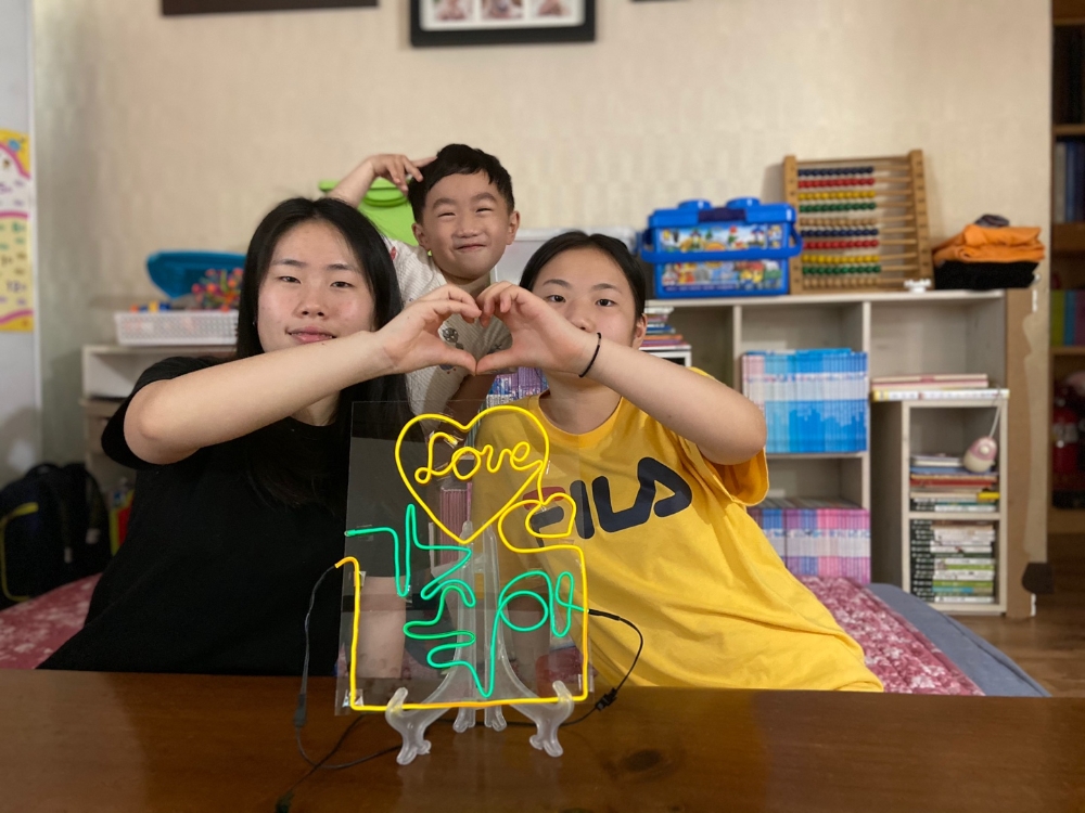 DL이앤씨 직원 자녀들이 온라인 클래스를 들으며 직접 만든 네온사인 작품을 선보이고 있다.(사진=DL이앤씨)