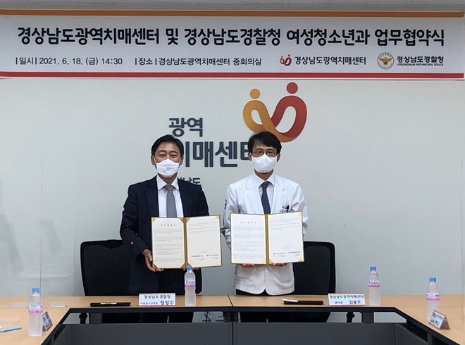 경남경찰청 정성수 여성청소년과장(왼쪽)과 경상남도광역치매센터 김봉조 센터장이 업무협약서를 내보이며 기념촬영.(사진제공=경남경찰청)