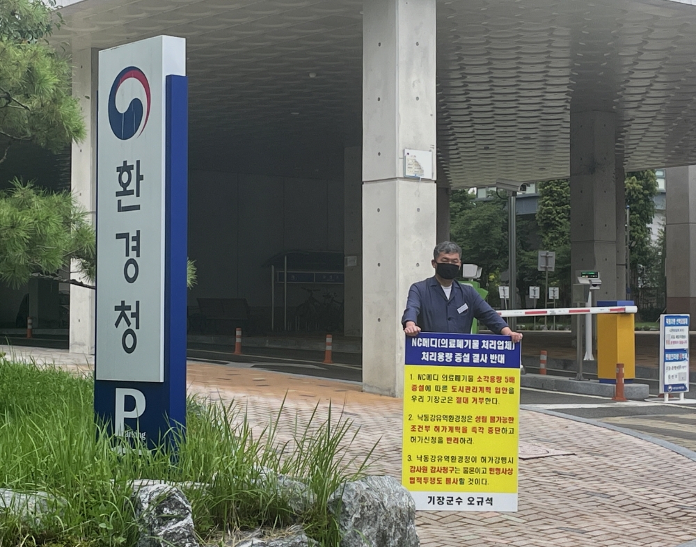 오규석 기장군수는 일요일인 7월 18일 오전 11시 20분 허가청인 낙동강유역환경청(창원시 의창구) 앞에서 정관읍 용수리에 위치한 의료폐기물중간처분업체(소각)인 NC메디(주)의 소각용량증설 변경허가를 반대하는 25번째 1인 시위를 진행하고 있다.(사진제공=부산 기장군)