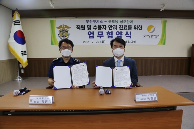 부산구치소 김영식 소장과 굿모닝성모안과 박진용 대표원장이 7월 20일 업무협약서를 내보이며 기념촬영.(사진제공=부산구치소)