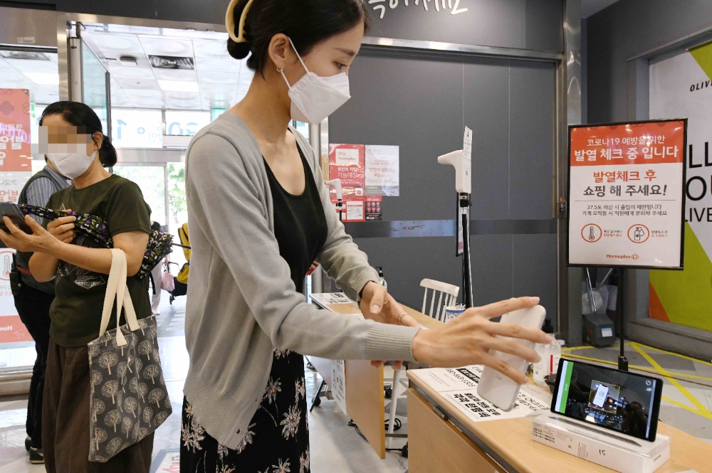 고객들이 30일 서울 등촌동 홈플러스 강서점 출입을 위해 정문에서 QR코드를 찍고 있다. 홈플러스(사장 이제훈)는 대형마트 QR코드 인증 의무화 조치에 따라 오늘부터 전국 138개 매장에서 QR코드 인증을 시행한다고 30일 밝혔다. 중앙재난안전대책본부는 지난 27일 ‘백화점 등 대규모 점포 출입명부 강화 방안’을 확정하고 사회적 거리두기 3단계 이상 격상 시 QR코드 등 출입명부 관리 도입을 의무화한다고 밝힌 바 있다. 홈플러스는 지상 및 주차장 등 필수 동선만으로 최소화한 고객·직원·협력사 출입구에 QR코드 인증용 태블릿PC를 설치했다. 아울러 고객 밀집과 대기를 최소화하기 위해 안심콜을 도입하고 수기명부도 함께 비치했다. 또 매장 출입구 고객 발열체크 강화를 위해 주요 점포에 별도 파트타임 인력을 충원해 운영하고 있다.