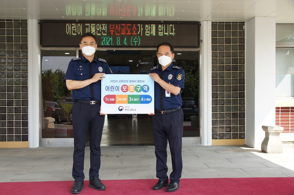 김홍대 총무과장(사진왼쪽) 등이 어린이 교통안전 릴레이 챌린지에 동참하고 있다.(사진제공=부산교도소)