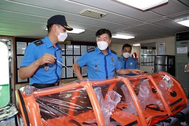 김홍희 해양경찰청장(왼쪽 두번째)이 울산해양경찰서 1009함을 방문하여 감염환자 이송용 음압캐리어를 살펴보고 있다.(사진제공=울산해양경찰서)