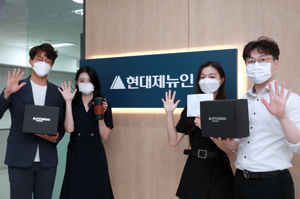 경기도 성남시에 위치한 현대제뉴인 본사에서 웰컴키트를 증정받은 직원들이 환하게 웃고 있다.(사진=현대제뉴인)