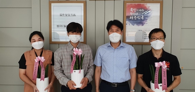 정성수 소장이 시보해제 신규 공무원 3명에게 청렴화분을 전달하고 기념촬영.(사진제공=안산준법지원센터)