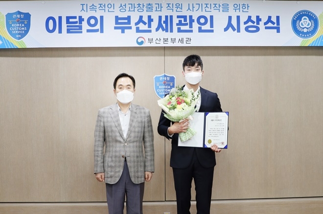 김재일 부산본부세관장(왼쪽)이 19일 8월의 부산세관인에 선정된 김승범 관세행정관과 기념촬영.(사진제공=부산본부세관)