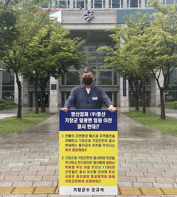 오규석 기장군수는 방산업체 ㈜풍산의 기장군 일광면 일원 이전을 결사반대하며, 8월 24일 오전 10시 20분 부산시청 앞에서 비를 맞으며 1인 시위를 진행하고 있다.(사진제공=부산 기장군)