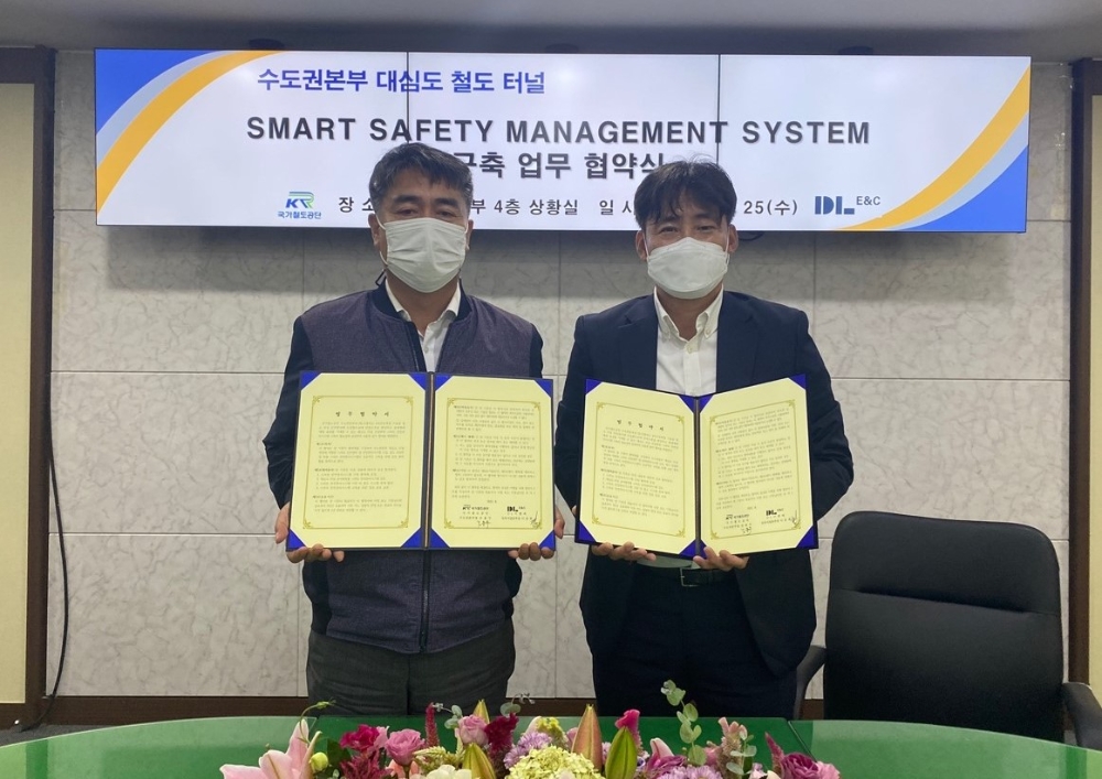 DL이앤씨 이동희 토목사업본부장(오른쪽)과 국가철도공단 김용두 수도권본부장(왼쪽)이 사진 촬영을 하고 있다.(사진=DL이앤씨)