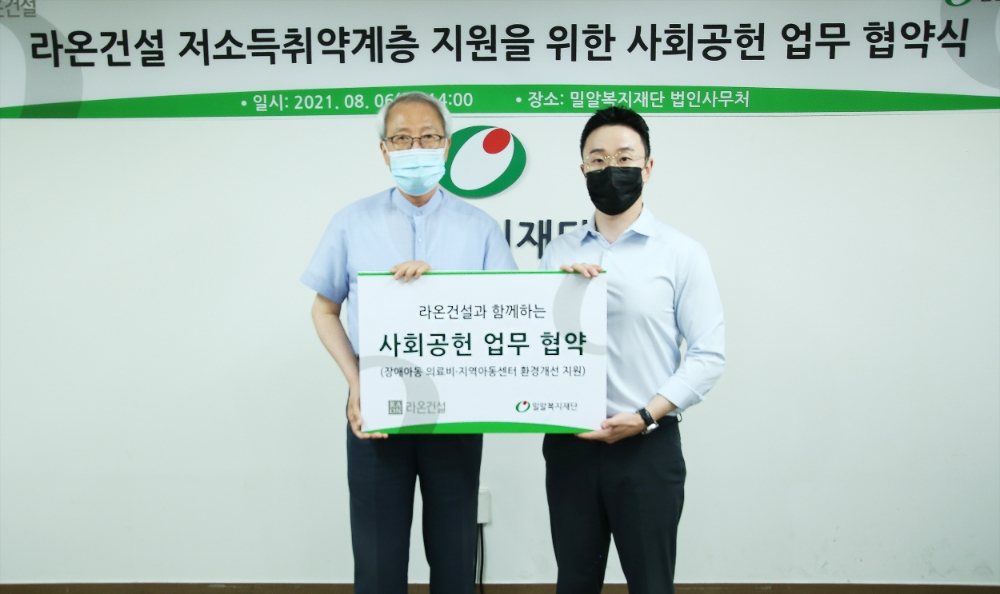 손형석 라온건설 기획본부장(오른쪽)과 정형석 밀알복지재단 상임대표가 지난 8월 저소득취약계층 지원을 위한 사회공헌 업무 협약 체결 후 기념사진을 촬영하고 있다.(사진=라온건설)