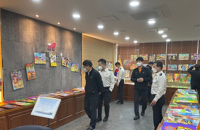 소방서 직원들이 불조심 포스터 및 그림을 감상하고 있다.(사진제공=부산소방재난본부)