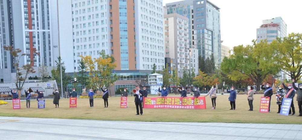 인천시청 앞에서 화수·화평구역 주택재개발정비사업조합원들이 현수막을 들고 성명서를 발표하고 있다.