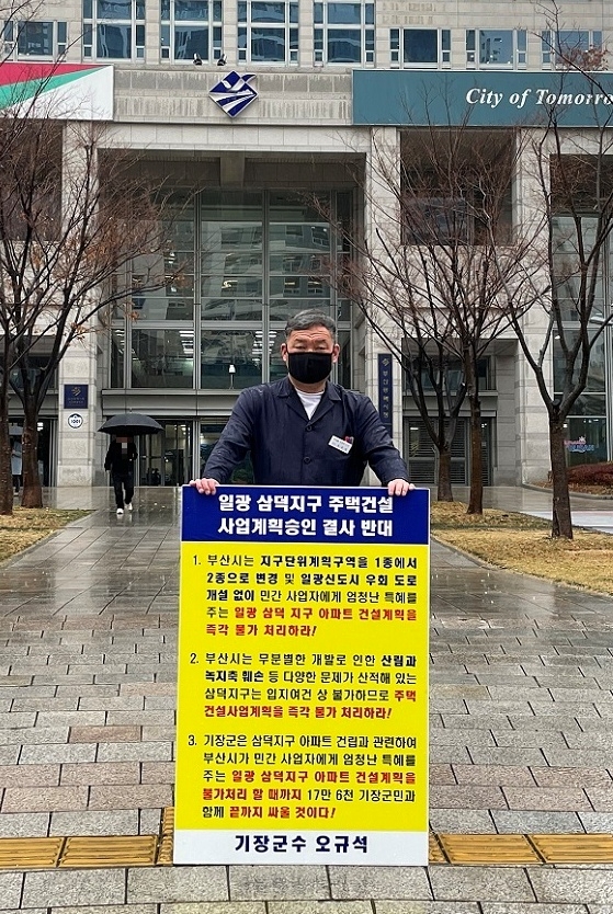 오규석 기장군수는 11월 30일 부산시의 주택사업 공동심의회에 앞서 오전 9시 35분 부산시청 앞에서 우천중에도 불구하고 비를 맞으며 일광 삼덕지구 주택건설사업 계획 승인을 결사반대하는 36번째 1인 시위를 하고 있다.(사진제공=부산 기장군)