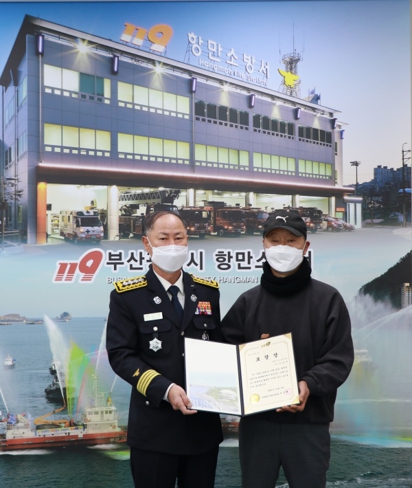 이준택 항만소방서장이 화재진압에 기여한 오승모 씨에게 표창을 수여하고 기념촬영.(사진제공=부산소방재난본부)