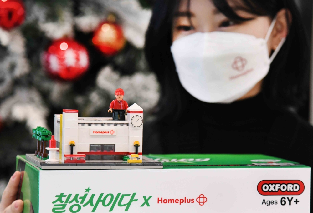 <사진설명> 모델이 16일 서울 강서구 홈플러스 본사에서 ‘칠성사이다 옥스포드 블록 세트’를 선보이고 있다. 홈플러스는 롯데칠성 및 옥스포드와 협업을 통해 ‘칠성사이다 옥스포드 블록세트’를 선보인다고 밝혔다. 이 상품은 ‘칠성사이다’와 ‘칠성사이다 제로’ 500ml 각 5병씩 총 10병을 비롯해 홈플러스 매장 외관을 모델로 한 옥스포드 블록 세트로 구성됐다. 홈플러스 매장 특유의 시계탑과 외벽 색상 등 특징을 살려 조립하며 재미를 느낄 수 있다. 오는 22일까지 홈플러스 온라인을 3000세트 한정으로 사전예약 판매되며, 오는 28일부터 31일까지 배송될 예정이다.