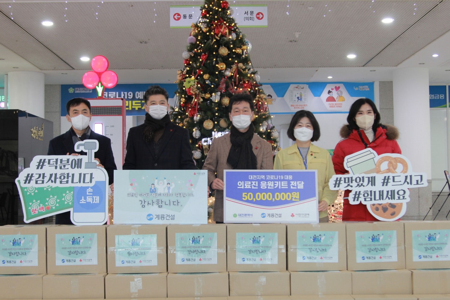 계룡건설 이승찬 사장(왼쪽부터 3번째)이 지난 24일 대전시청광장 임시선별검사소를 방문해 ‘응원키트’ 전달식을 진행했댜.(사진=계룡건설)