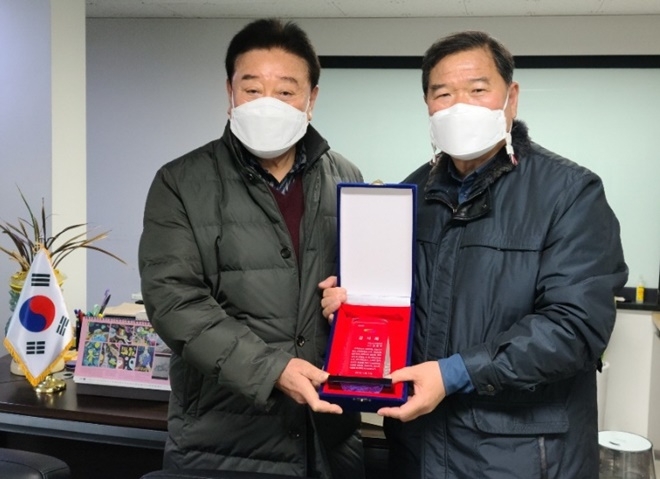 노경구 행정자치국장이 기장군 발전에 힘쓴 김동주 전 국회의원(왼쪽)에게 기장군수 명의 감사패를 수여하고 기념촬영.(사진제공=부산 기장군)