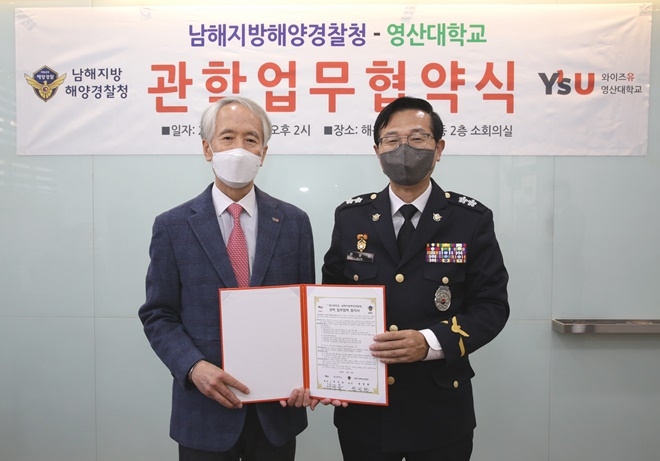 영산대학교 부구욱 총장과 남해해경청 윤성현 청장이 업무협약서를 내보이며 기념촬영.(사진제공=남해해경청)