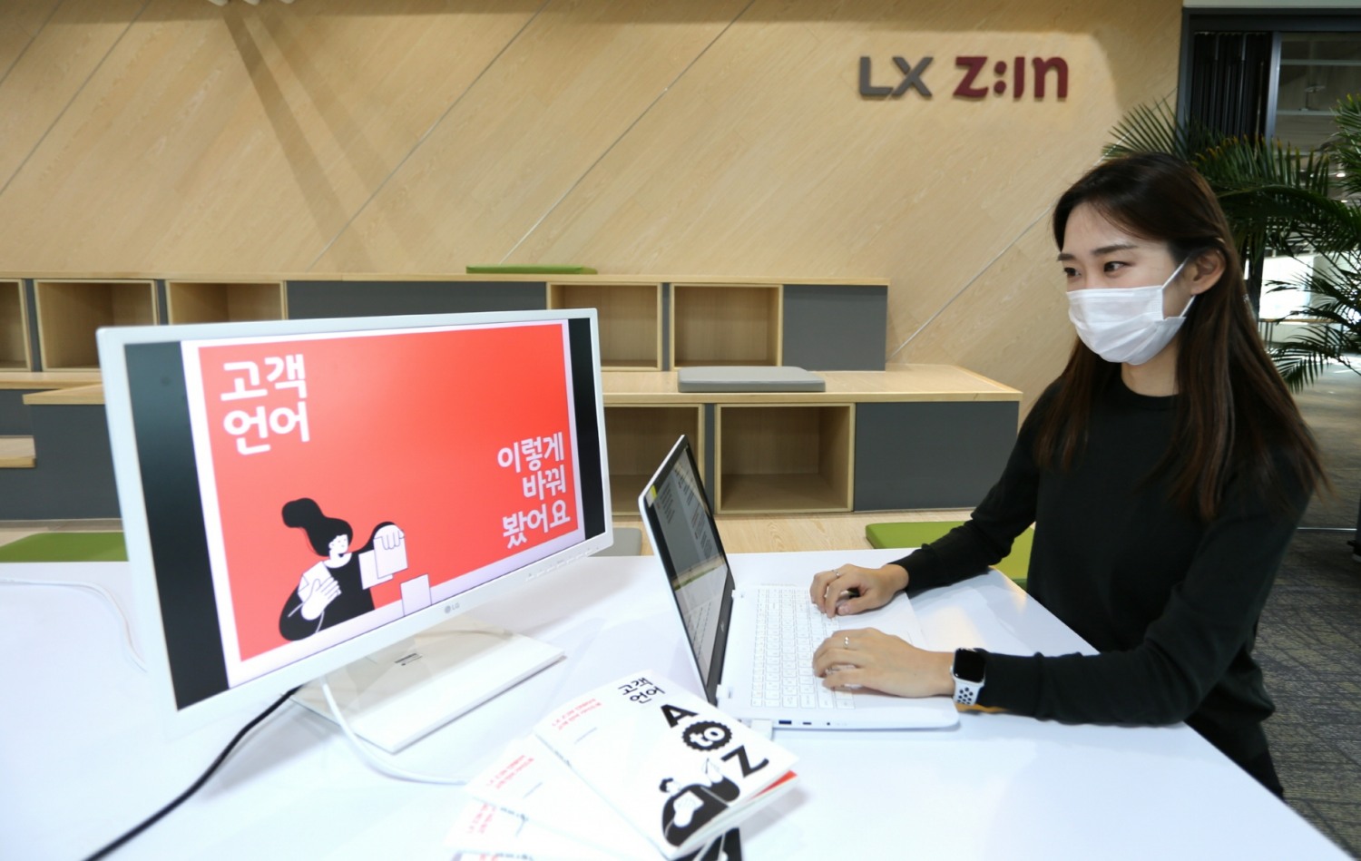 LX하우시스 임직원이 'LX Z:IN 인테리어 고객 언어 가이드북'을 살펴보고 있는 모습.(사진=LX하우시스)