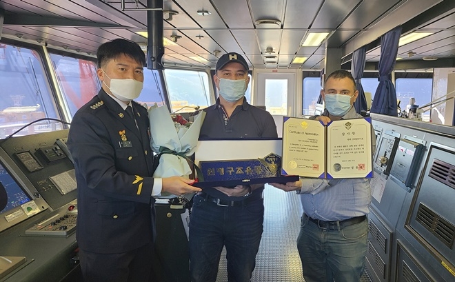 남해해경청 구조안전과 지국현 과장이(왼쪽) 현대 프리빌리지호에 해양경찰청장 감사장 및 인명구조 명패를 수여하고 기념촬영을 하고 있다.(사진제공=남해지방해양경찰청)