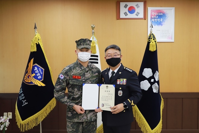 이병철 서장이 해병대 2사단 소속 이동재 상병에게 표창장 수여하고 기념촬영.(사진제공=부산해양경찰서)