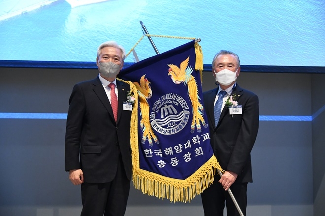 19대 박신환 회장(좌)과 20대 정영섭 회장(우)이 총동창회기를 들고 기념 촬영하고 있다.(사진제공=한국해양대학교)