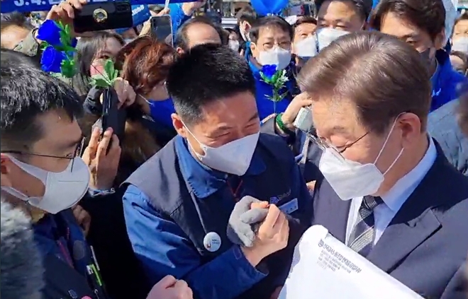 정병천 현중지부장이 3일 낮 12시서울 종로 보신각 터에서 이재명 대통령 후보를 만나 ‘현대중공업 현안문제와 조선산업의 몰락으로 고통당하는 노동자들에 대한 입장 서한’을 전달하고 있다. (사진제공=금속 현대중공업지부)