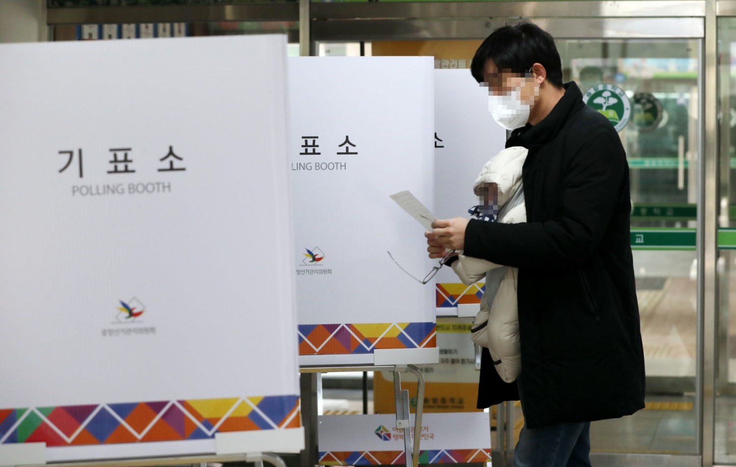 제20대 대통령선거 본투표일인 9일 청주 솔밭중학교에 마련된 투표소에서 한 시민이 아이를 안고 투표하고 있다.(사진=연합뉴스)