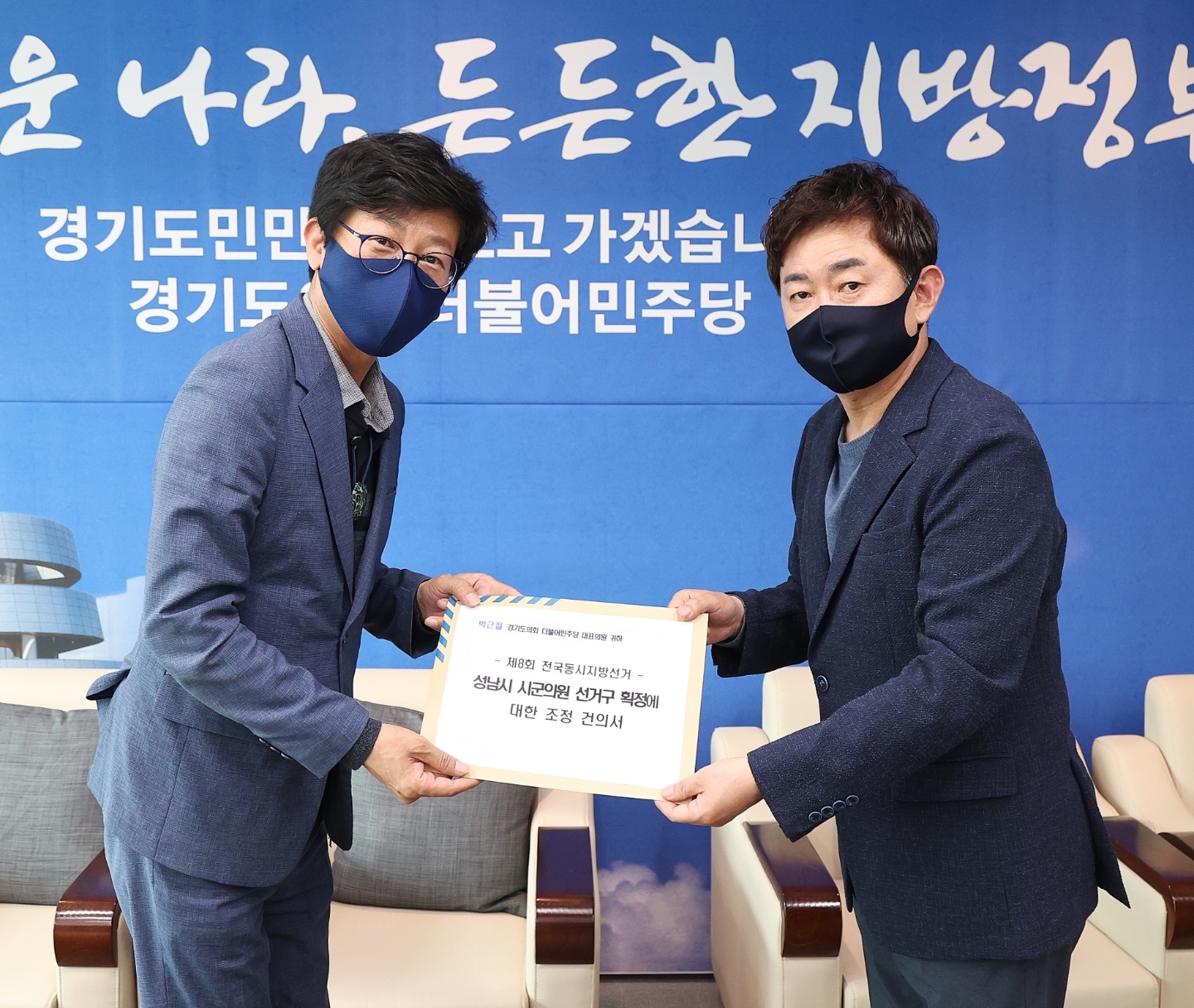국중범도의원이 더불어민주당 박근철 대표의원에게 조정 건의서를 전달하고 있다.