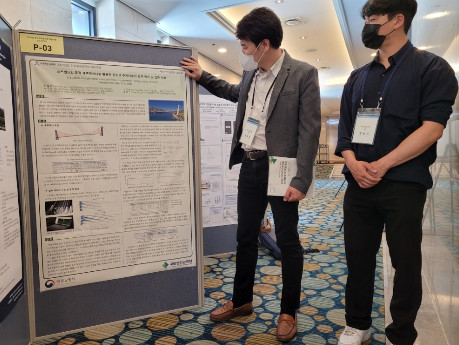 국토안전관리원 직원들이 한국강구조학회 학술대회에서 발표한 논문 자료에 대해 살펴보고 있다.(사진=국토안전관리원)
