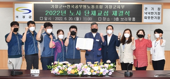 기장군(군수 오규석, 왼쪽 여섯번째)과 전국공무원노동조합 기장군지부(지부장 주정주, 왼쪽 다섯번째)는 6월 20일 군청 상황실에서 노동조건 및 근무환경 개선을 위한 ‘2022년 단체협약’을 체결하고 기념촬영.(사진제공=부산 기장군)