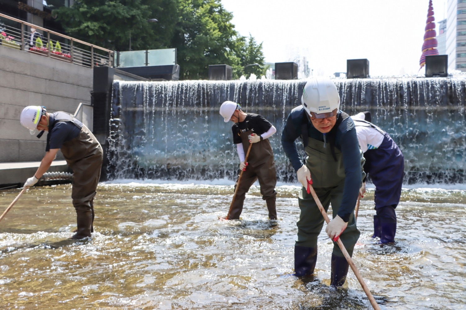 포스코O&M 김정수 대표(우측 두번째)가 직원들과 청계천 하상 청소를 실시하고 있다.(사진=포스코O&M)