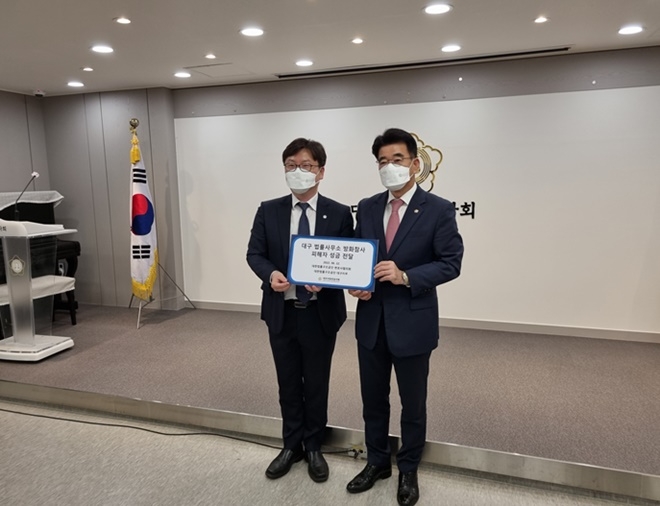 이기호 대한법률구조공단 대구지부장(왼쪽)이 대구지방변호사회 이석화 회장에게 성금을 전달하고 있다.(사진제공=대한법률구조공단)