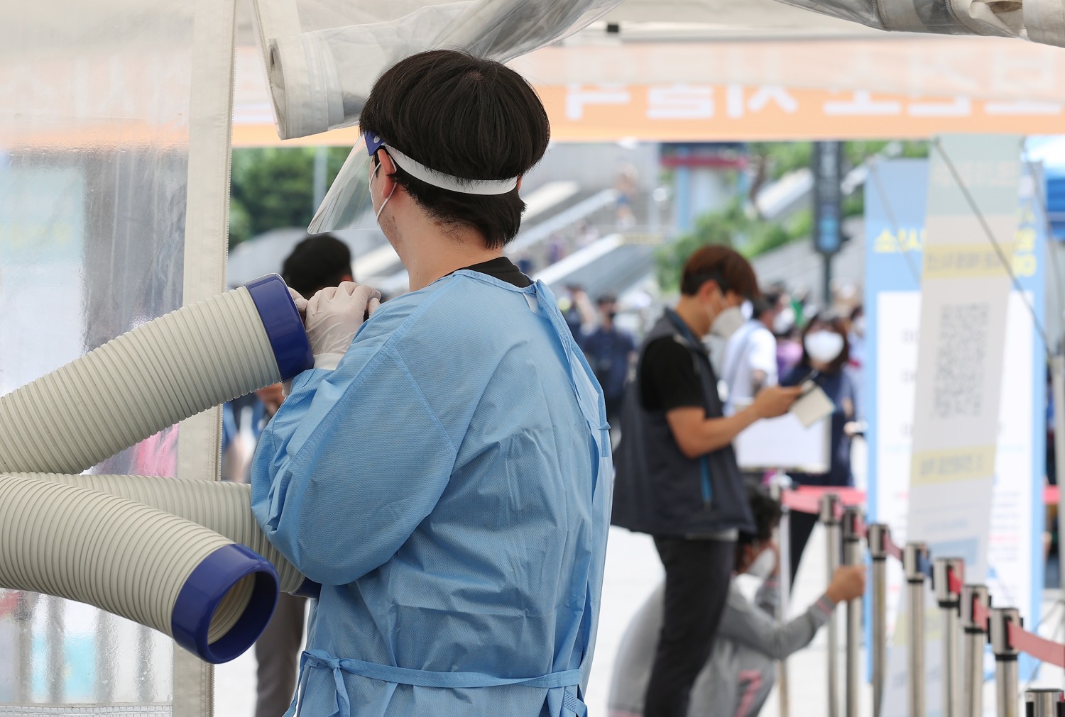 지난 28일 오후 서울역광장에 마련된 임시선별검사소에서 의료진이 냉풍기로 더위를 식히고 있다. 사진=연합뉴스