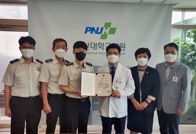 류승훈 중부소방서장이 부산대병원 정성원 부원장에게 소방청장 표창을 전수하고 기념촬영.(사진제공=부산소방재난본부)