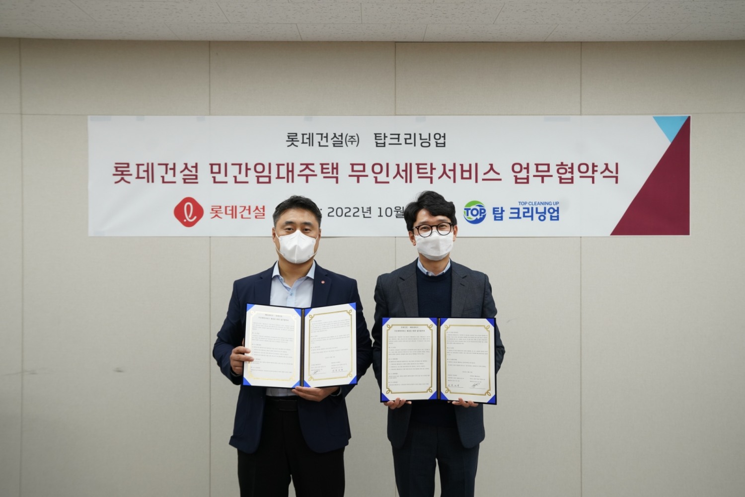 롯데건설 자산운영서비스팀 현재명 수석과 탑크리닝업 최용진 대표가 업무협약 체결 후 기념 촬영을 하고 있다.(사진=롯데건설)