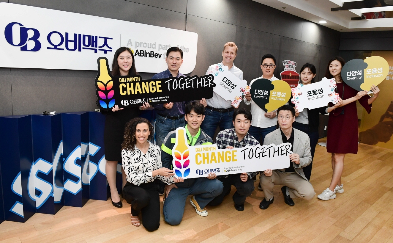 지난 10월 개최된 ‘다양성과 포용성(D&I)의 달’ 행사에서 오비맥주 D&I위원회의 공동위원장을 맡고 있는 김종주 인사부문 부사장(뒷줄 왼쪽에서 두 번째), 배하준 대표(세번째), 구자범 법무·정책홍보부문 부사장(네번째), 나탈리 보르헤스 구매·지속가능경영부문 부사장(앞줄 왼쪽 첫 번째)가 기념사진을 촬영하고 있다. 사진=오비맥주