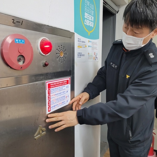 옥내전소화전 스티커를 부착하고 있다.(사진제공=동래소방서)