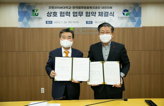 이동진 건양사이버대학교 총장(사진왼쪽)과 김대기 공단 대전지부장이 업무협약서를 내보이며 기념촬영.(사진제공=한국법무보호복지공단대전지부)