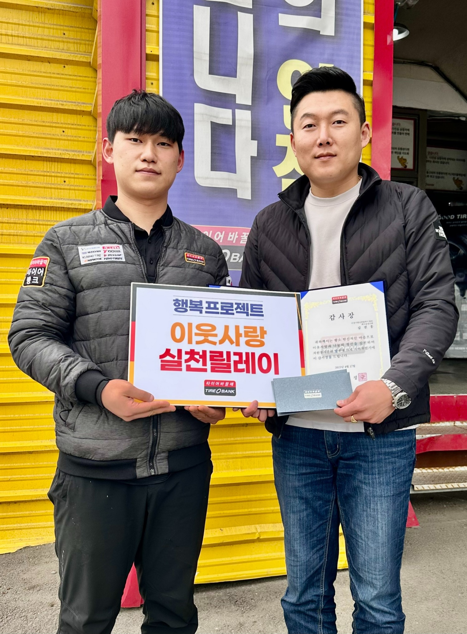 타이어뱅크 양주시청점에서 김민수 사업주(왼쪽)와 김진홍씨(오른쪽)가 감사장, 타이어 교환권 전달 후 기념 촬영을 하고 있다.(사진=타이어뱅크)