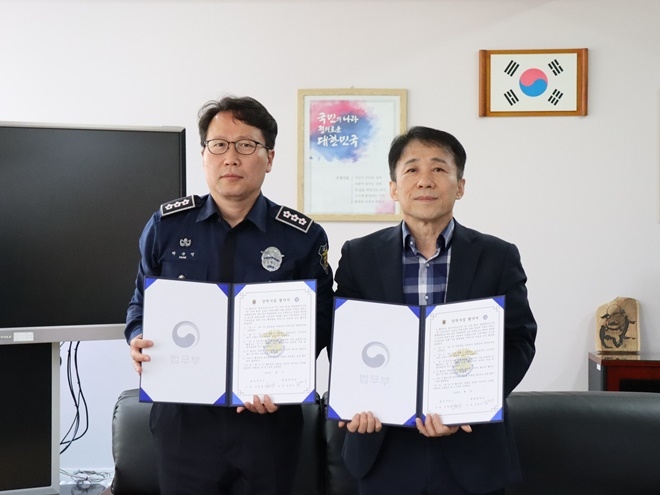 박규연 울산구치소 총무과장과 강권식 청량중학교 교장이 11일 업무협약서를 내보이며 기념촬영.(사진제공=울산구치소)