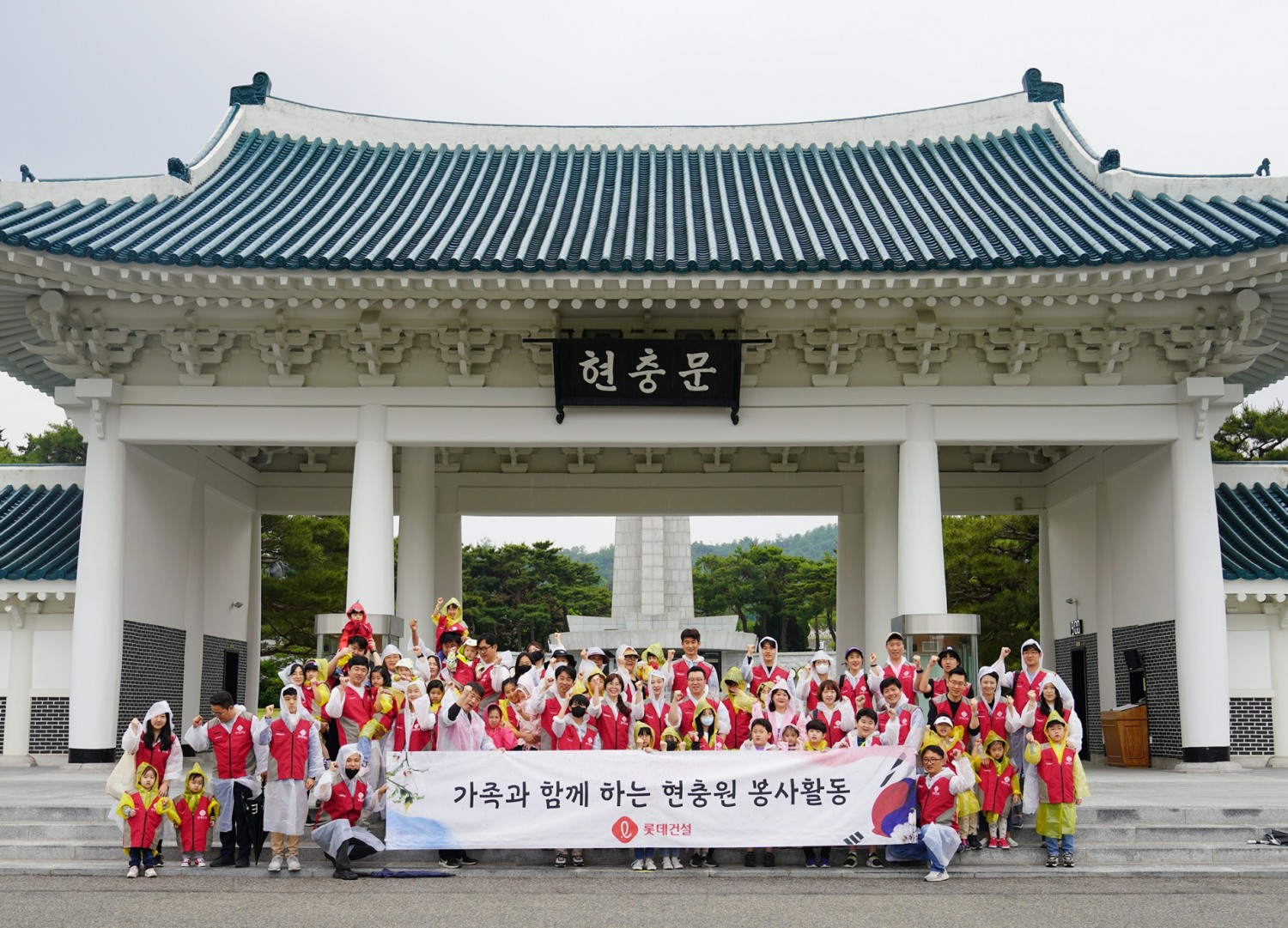 롯데건설 임직원과 가족들이 현충문 앞에서 봉사활동 후 기념촬영을 하고 있다.(사진=롯데건설)