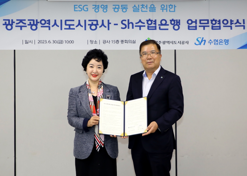 수협은행 강신숙 은행장(왼쪽)과 광주도시공사 정민곤 사장이 협약서에 서명하고 기념촬영을 하는 모습. 사진=Sh수협은행