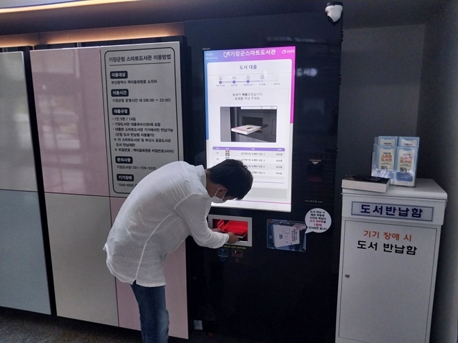 군청사를 방문한 민원인이 스마트도서관을 이용하고 있다.(사진제공=부산 기장군)