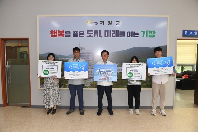 정종복 기장군수(가운데)가 17일 ‘수산물 소비 및 어촌휴가 장려’ 캠페인에 참여하고 있다.(사진제공=부산 기장군)