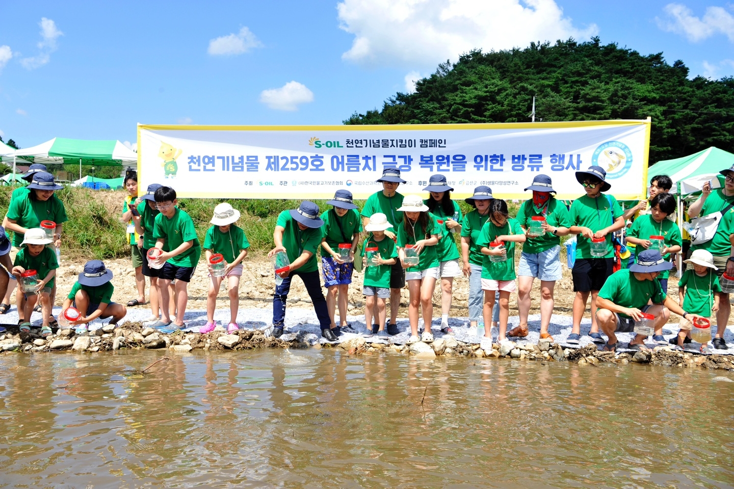 에쓰오일 직원 가족들이 19일 충남 금산군 부리면 금강 하천변에서 어름치 치어 방류 활동과 하천 생태체험을 하고 있다.(사진=에쓰오일)