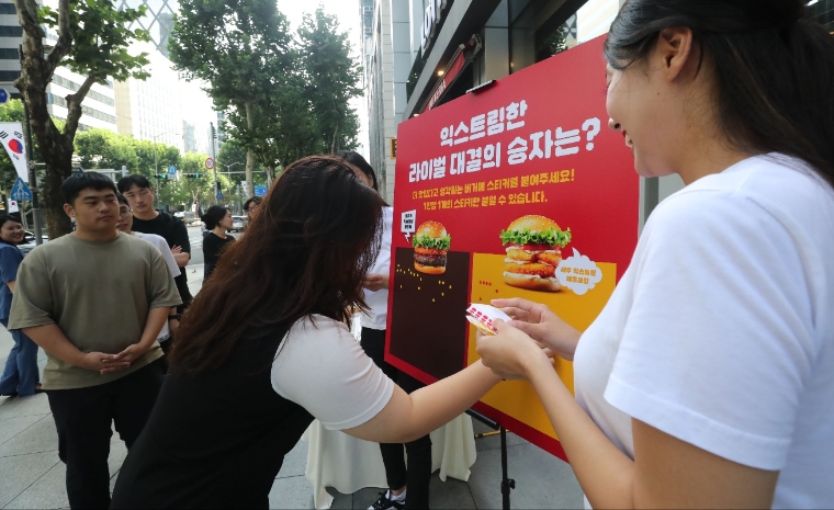 지난 17일 강남구에 위치한 롯데리아 선릉점에서 진행한 롯데리아 대표버거 라이벌전 시식회에서 고객이 투표를 하고 있다. 사진=롯데GRS