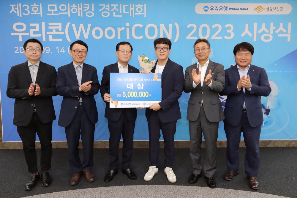 우리은행은 지난 14일 서울 중구 소재 우리은행 본점에서 제3회 모의해킹 경진대회 '우리콘(WooriCON) 시상식을 개최했다. 조병규 우리은행장(왼쪽 세번째), 김철웅 금융보안원장(오른쪽 두번째), 김백수 우리은행 정보보호그룹 부행장(오른쪽 첫번째), 박춘식 아주대학교 교수(왼쪽 두번째), 고려대 김휘강 교수(왼쪽 첫번째)가 대상 수상자와 기념촬영을 하고 있다. 사진=우리은행