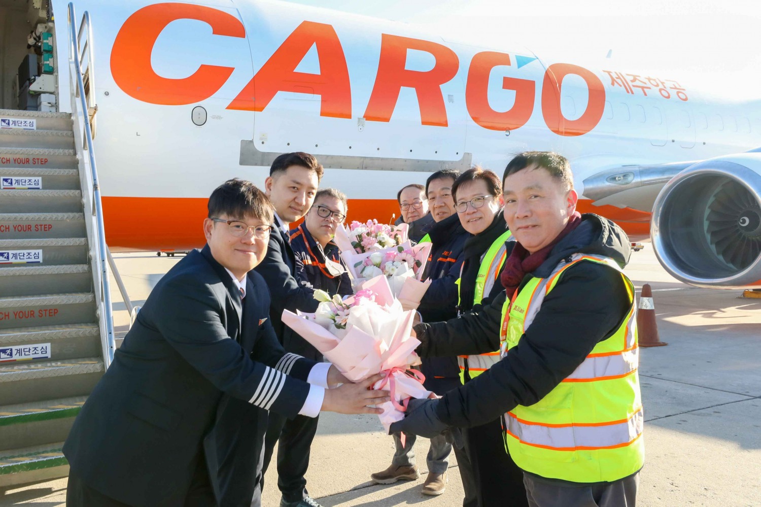 인천국제공항에서 윤성용 제주항공 운항본부장(사진 오른쪽 맨 앞), 박태하 제주항공 운항통제본부장(사진 오른쪽 두번째), 구광수 제주항공 안전정비실장(사진 오른쪽 세번째), 신우균 제주항공 정비지원실장(사진 오른쪽 맨 뒤)이 화물2호기 도입을 맞아 직원들에게 꽃다발을 전달하고 있다.(사진=제주항공)