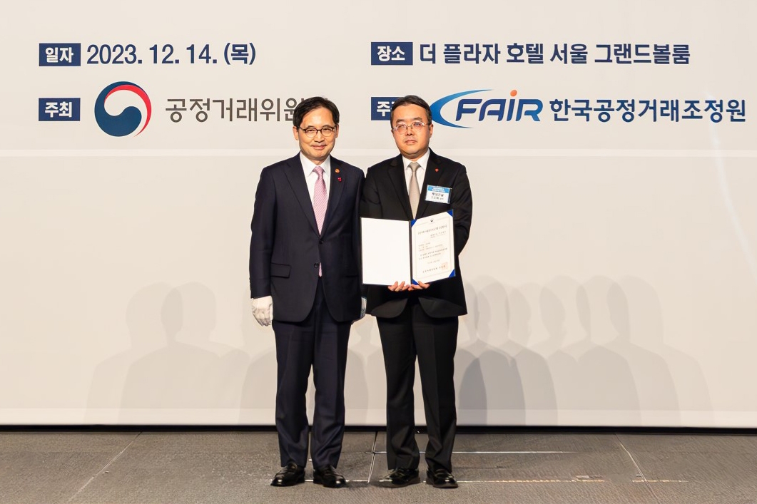 롯데건설 준법경영부문 조도휘 상무(사진 오른쪽)가 한기정 공정거래위원장(사진 왼쪽)으로부터 우수기업 평가증을 수여한 후 기념 촬영을 하고 있다.(사진=롯데건설)