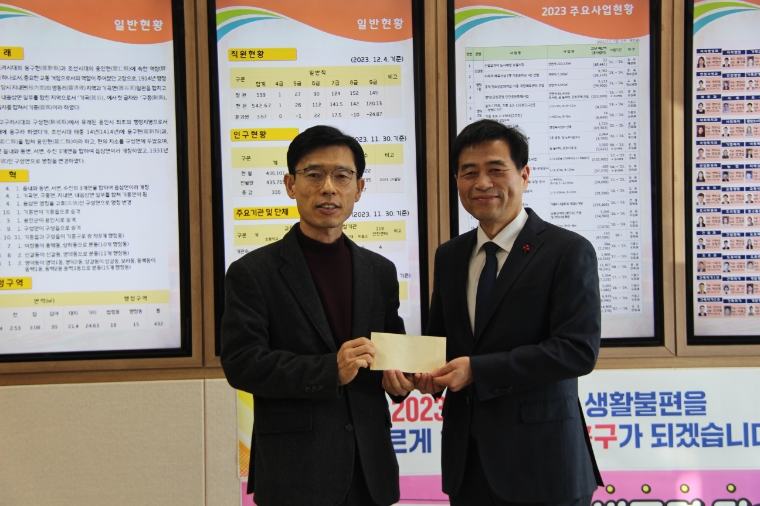 김민기 의원은 26일 이창호 기흥구청장(왼쪽)에게 12월 월급을 이웃돕기 후원금으로 전달하고 있다. (사진=의원실)